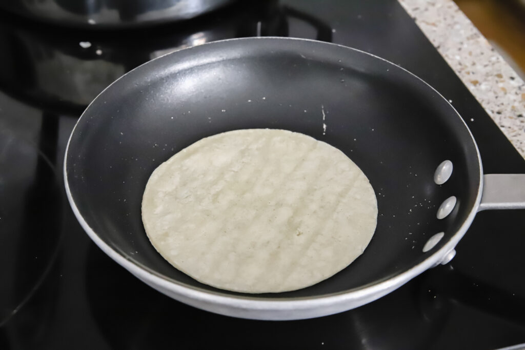 Heating up corn tortillas in a saucepan