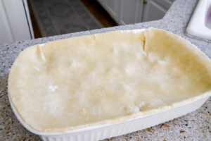 add homemade pie crust to the top of chicken pot pie.