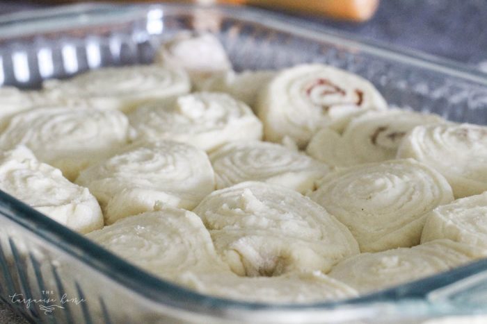 cinnamon rolls before baking, placed side-by-side in a baking dish