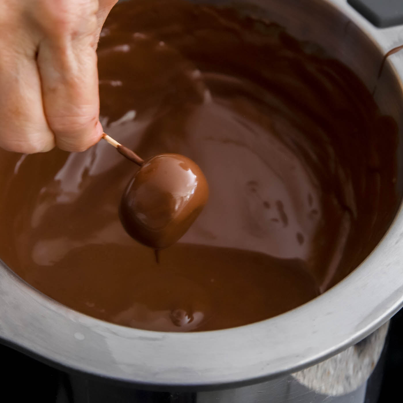 dipping peanut butter balls in melted chocolate