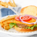 homemade burger with French fries and toppings like lettuce, cheese and tomato.