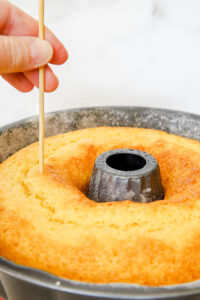 poking holes into coconut rum bundt cake.