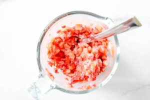 mix strawberries with flour for strawberry cheesecake cookies.