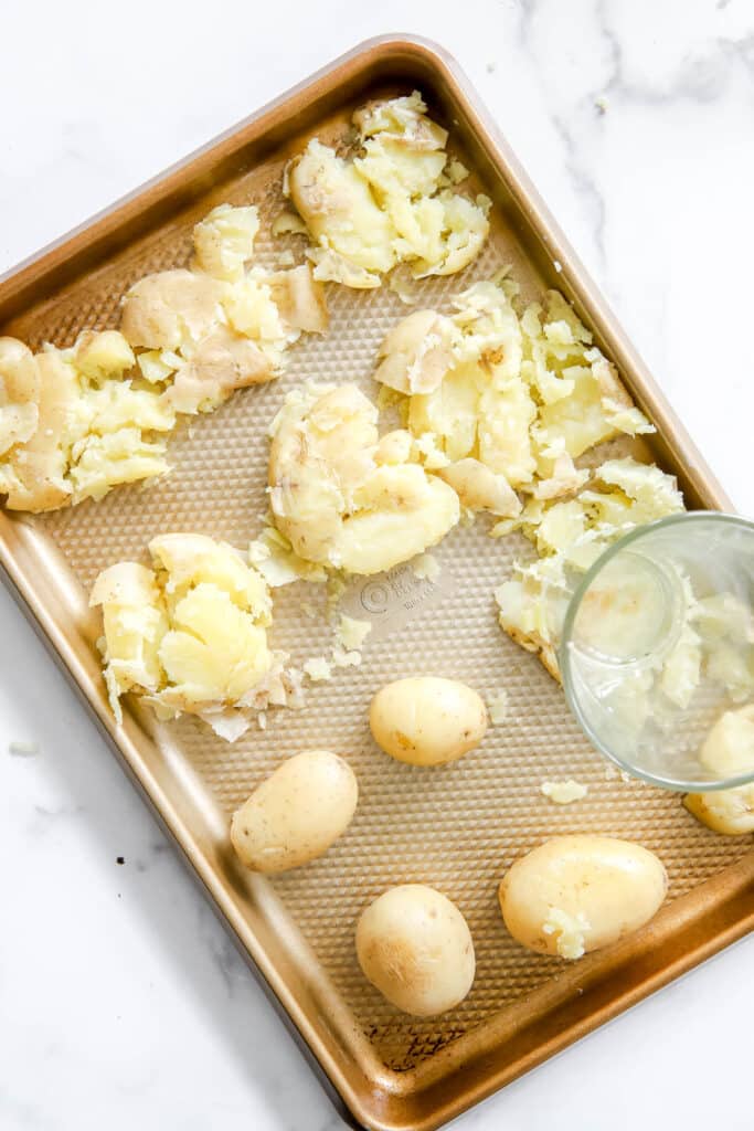 flatten potatoes with bottom of a cup.