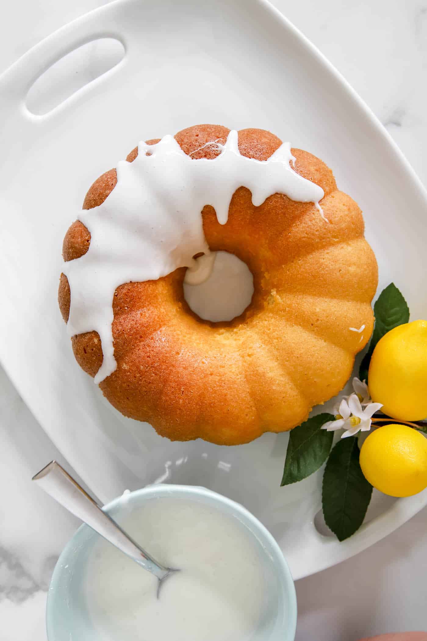 Drizzle icing on lemon bundt cake.