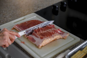 Slice bacon in half for bacon cracker appetizers