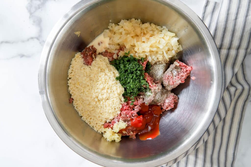 combining meatloaf ingredients in a bowl.