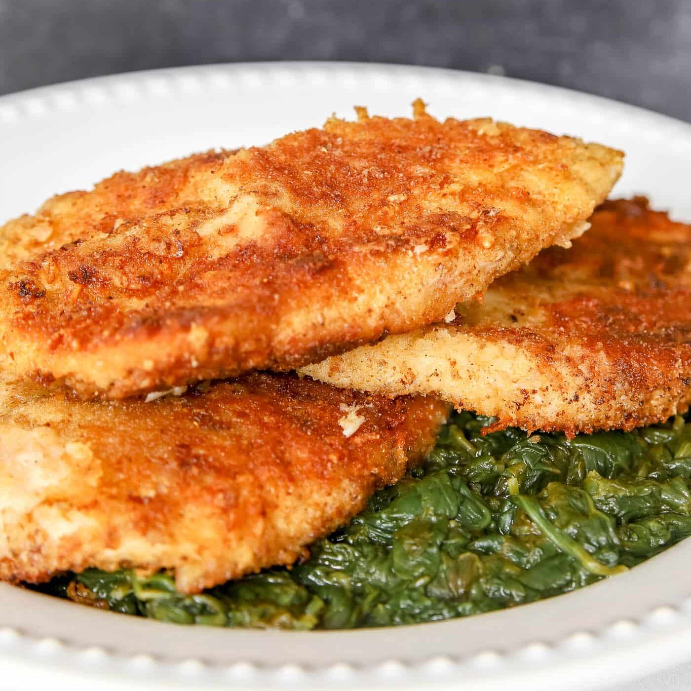 paremsan-crusted chicken on a bed of spinach