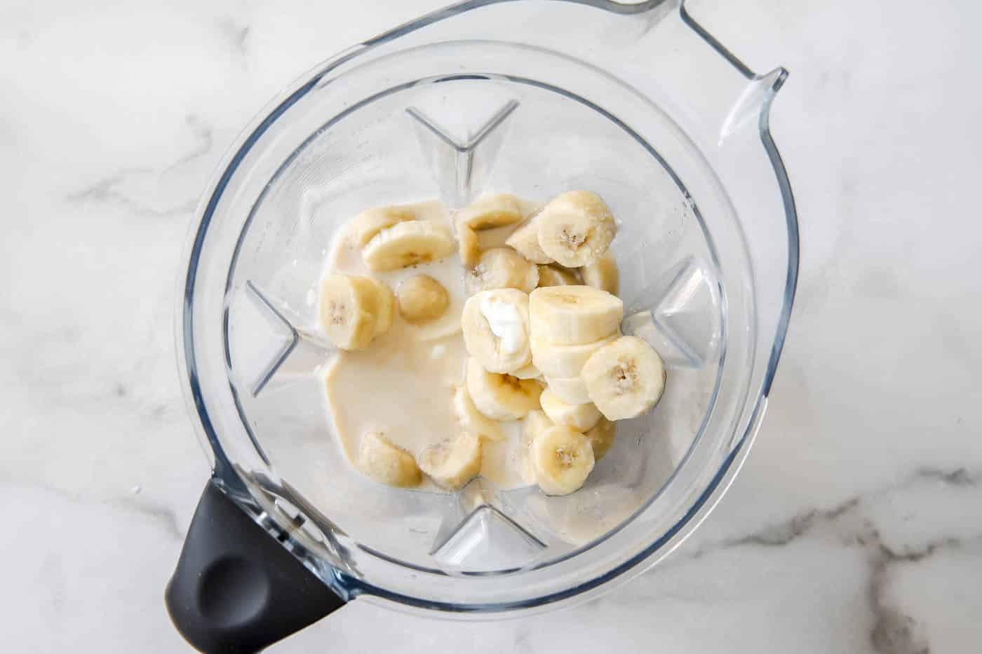 creamy banana smoothie ingredients in blender.
