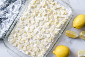 cubes of butter layered evenly over cake mix for lemon dump cake.