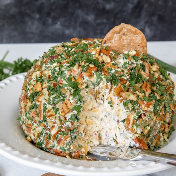 cheese ball with pineapple and bacon on a cracker.