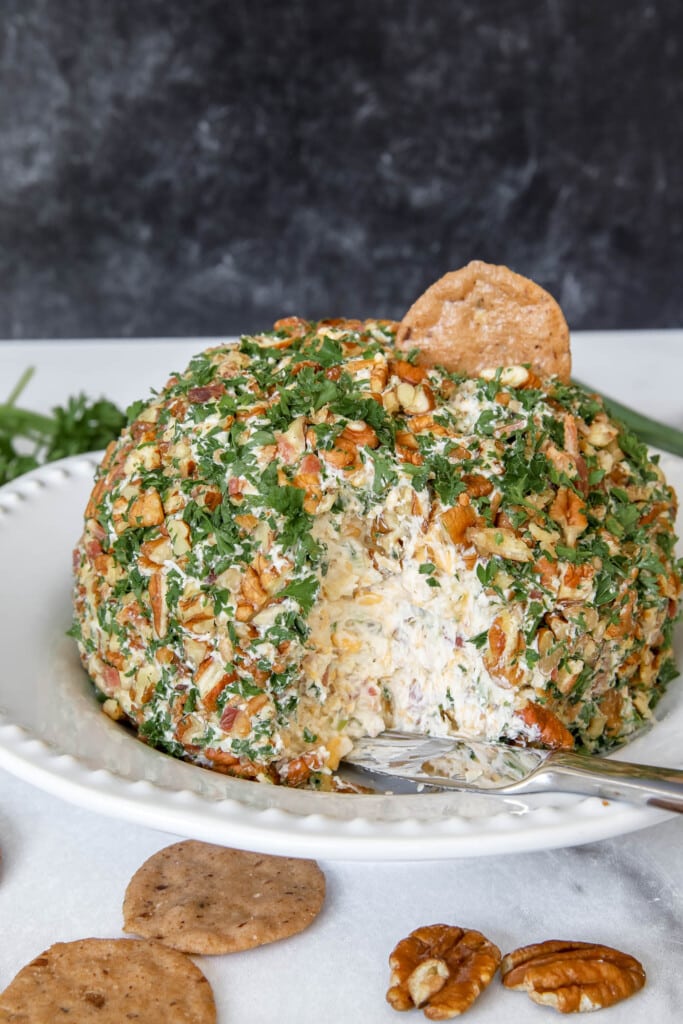 cheese ball with pineapple and bacon on a cracker.
