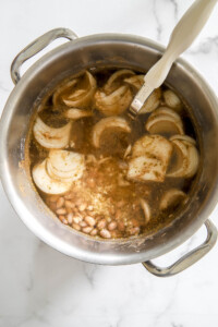 beans and onions in a pot for refried beans recipe.