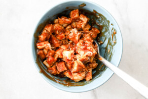 mixing chicken and barbecue sauce for bbq chicken nachos.