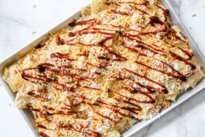 building bbq chicken nachos and finishing with cheese and bbq sauce.