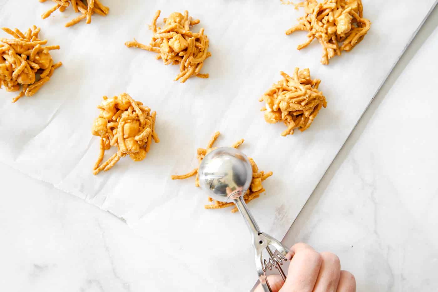 placing butterscotch haystacks on parchment paper.